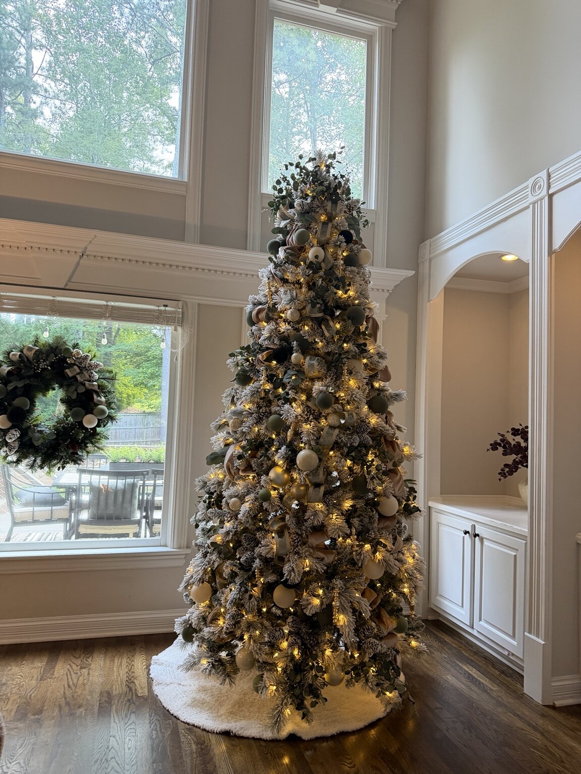 Flocked Christmas tree decorated in sage, ivory and warm metallic tones