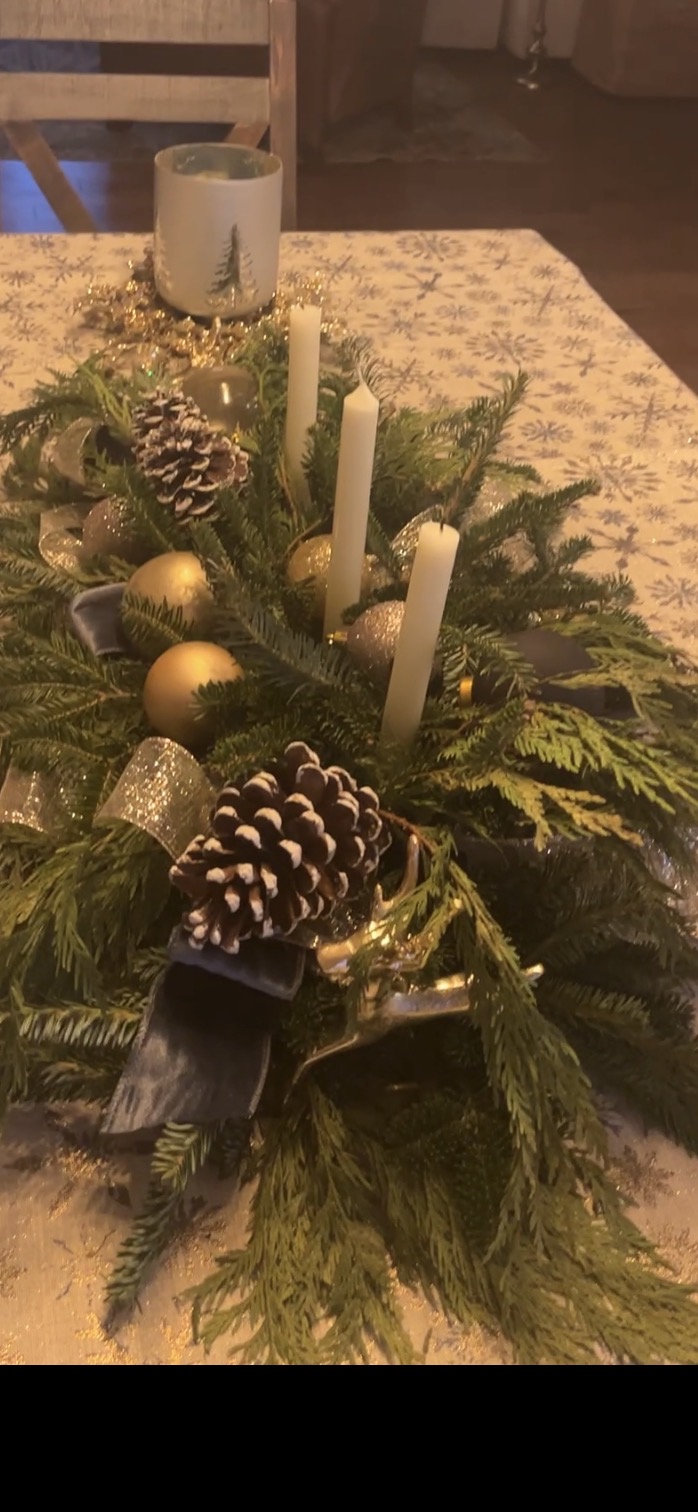 Fresh evergreen holiday centerpiece with candles, pinecones, gold ornaments and ribbon