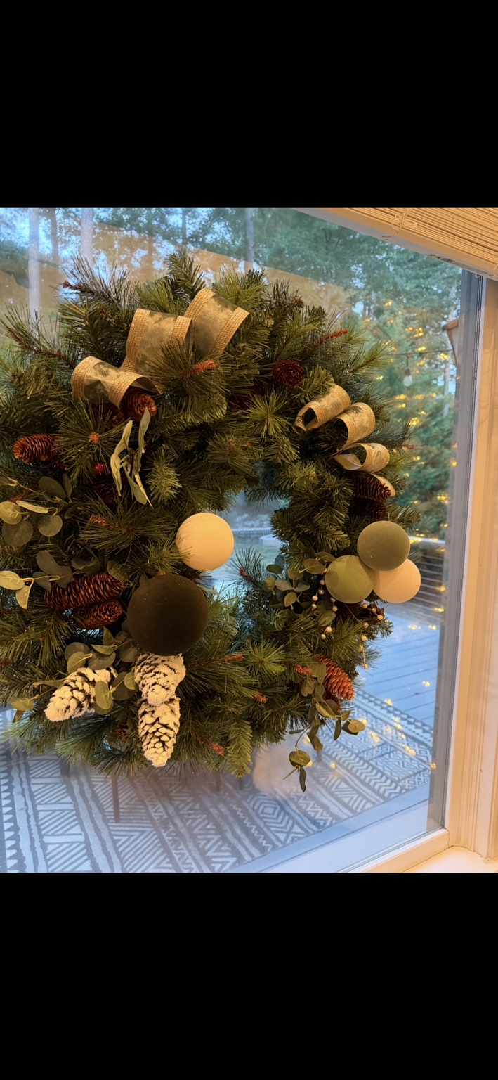 Full Christmas wreath styled with ribbon, pinecones and soft neutral ornaments