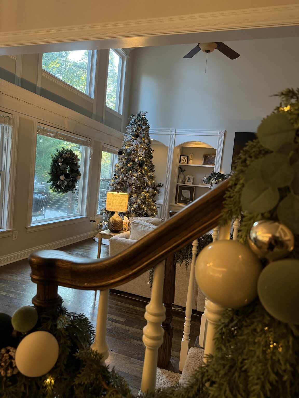 Holiday garland styled along a stairway with ornaments and lights